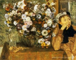 Une femme assise à côté d'un vase de fleurs