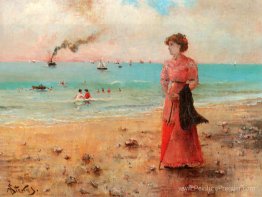 Jeune femme avec le parapluie rouge au bord de la mer